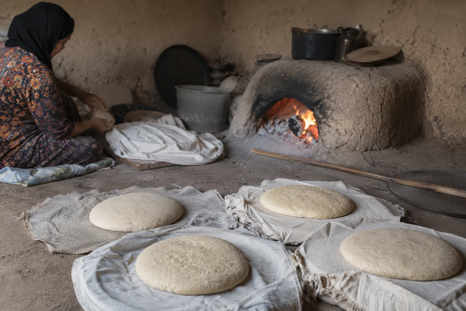 Homemade bread resting on cloths on the floor of a modest family kitchen