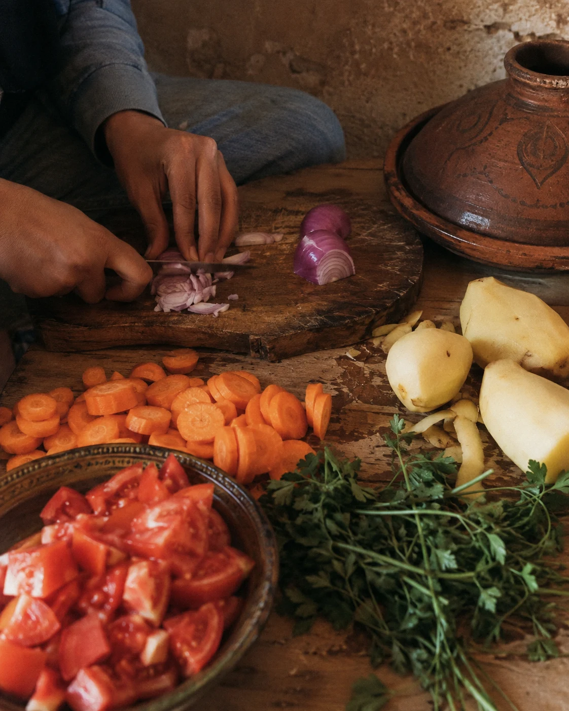 Hands cutting vegetables for a tajine