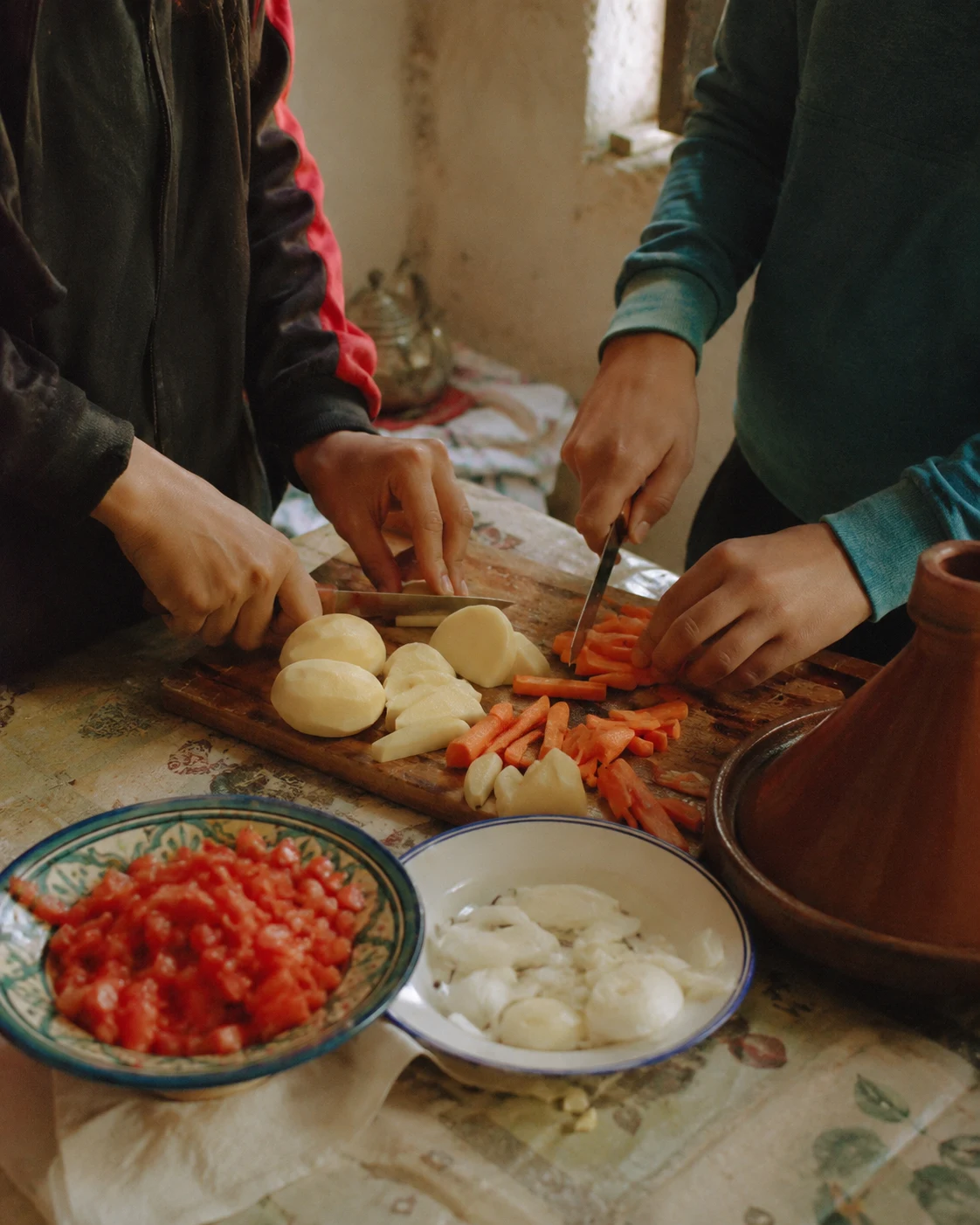 Hands preparing simple vegetables for a homemade tajine