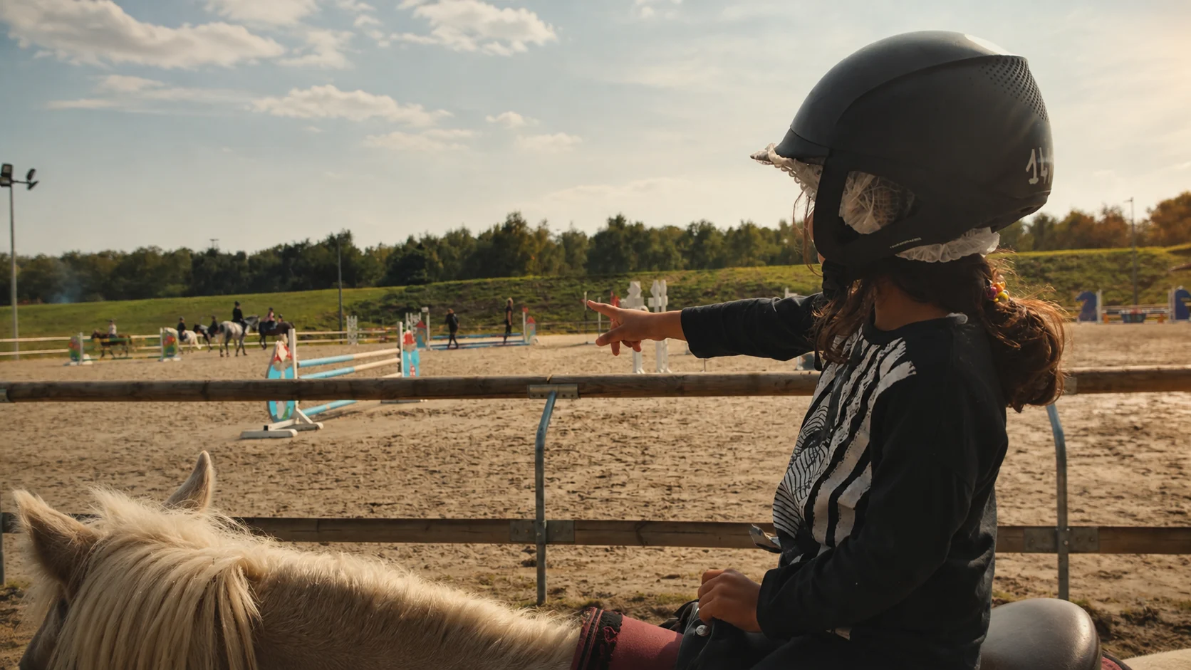 A young rider learning to ride during her early horse lessons