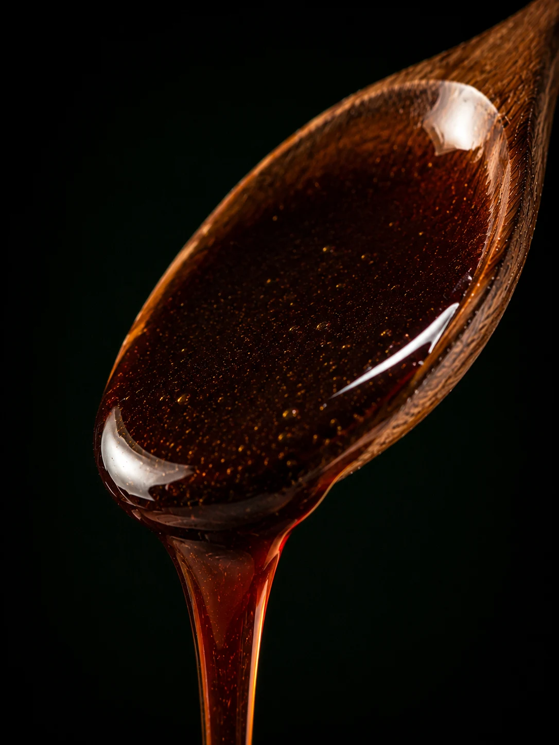 Dark Mexican avocado honey on a spoon