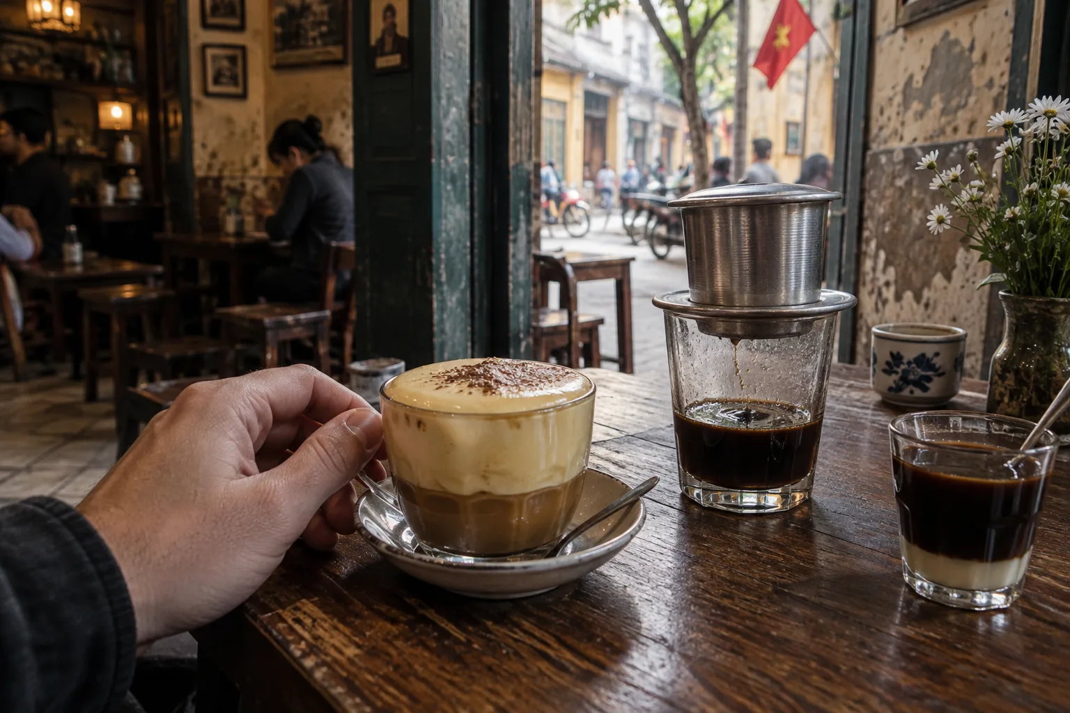 Hanoi coffee table with egg coffee, phin filter and condensed milk in a small local café setting